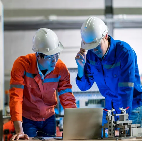 Technicians reviewing equipment at a workstation